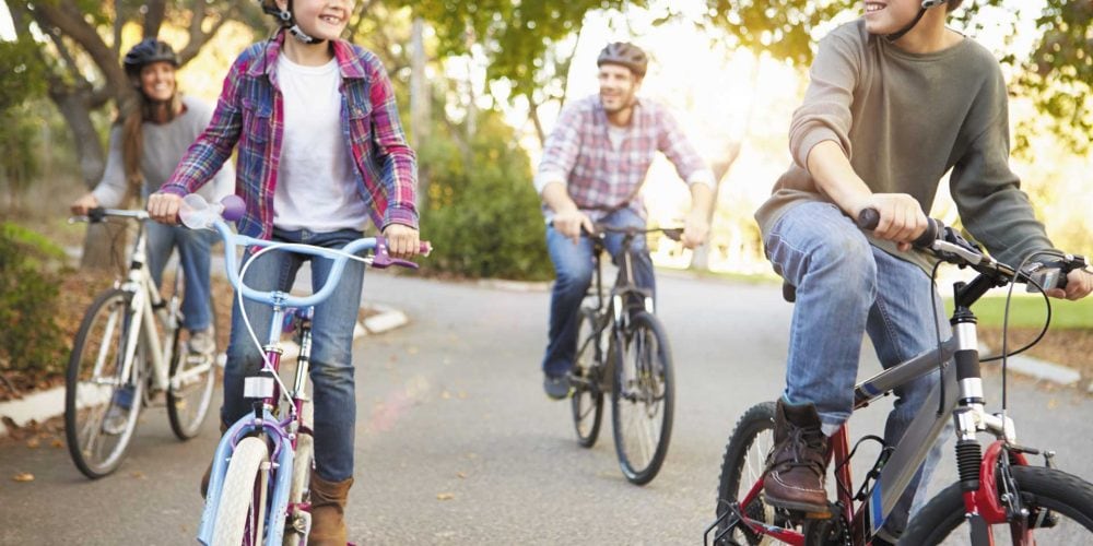 family-cycling-through-park